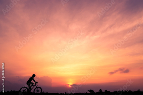Silhouette of cyclist ride bicycle on sunset background. A man Ride on bike on the road, Sport and active life concept