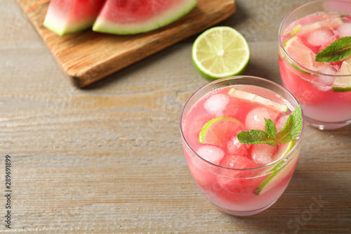 Tasty refreshing watermelon drink on wooden table. Space for text