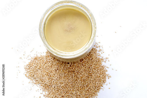tahini syrup in jar on white background