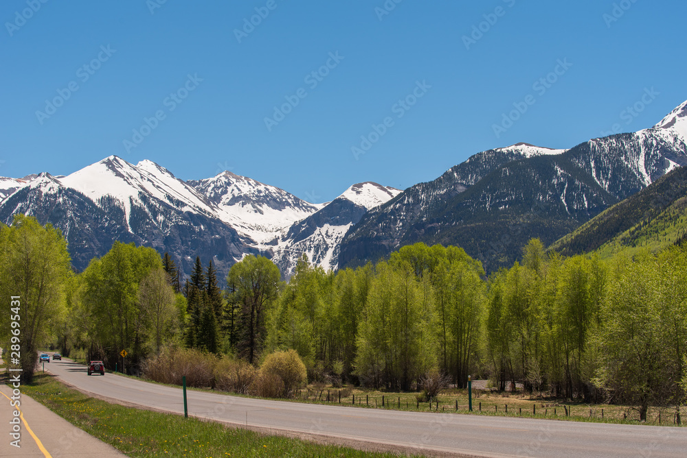 Telluride Colorado landscape of road, aspen trees and snow-dappled mountains Telluride Colorado landscape of road, aspen trees and snow-dappled mountains
