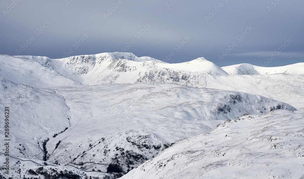 Obraz premium A winter snowy Lake District scene of Helvellyn, Striding Edge and Catstye Cam from Rampsgill Head near Hartsop.