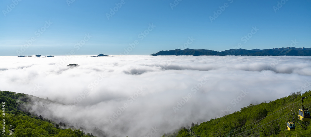 Obraz premium Panorama view from Unkai Terrace in summer time sunny day. Take the cable car at Tomamu Hoshino Resorts, going up to see the sea of clouds. Shimukappu village, Hokkaido, Japan