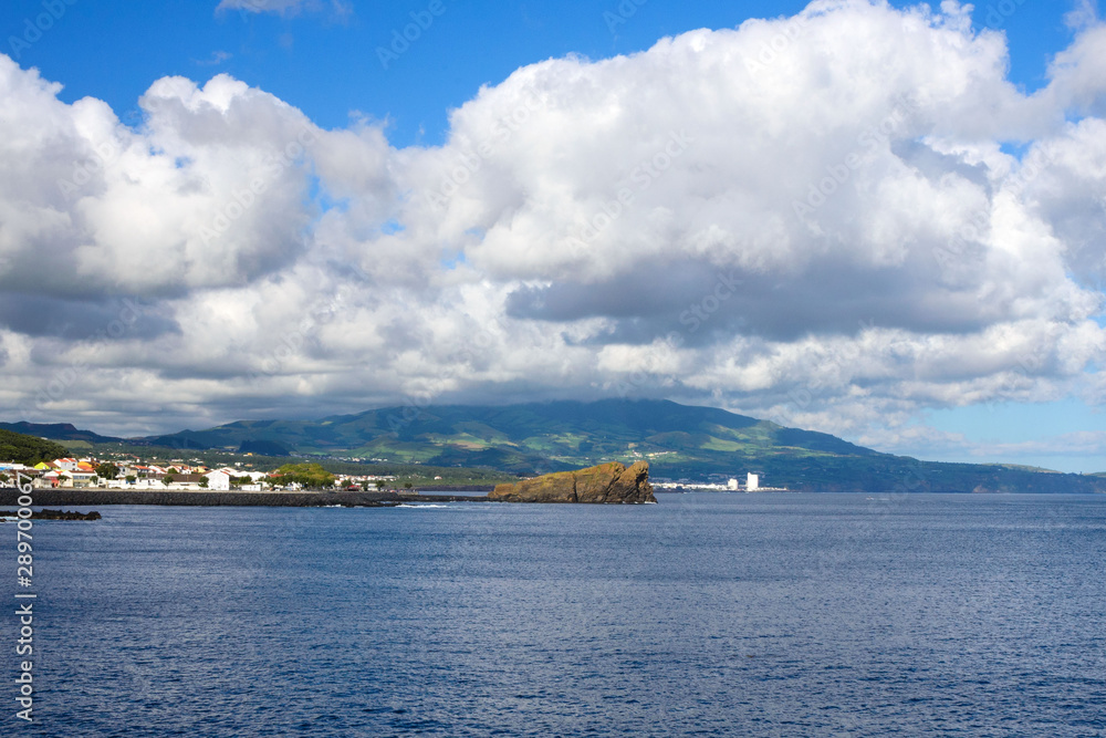 Beautiful white clouds on the blue sky and coast of the city of Ponta Delgada, San Miguel Island, Portugal.