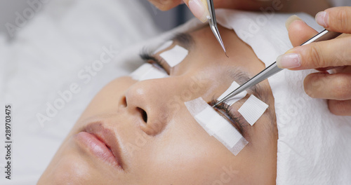 Asian woman with eyelash extension in beauty salon