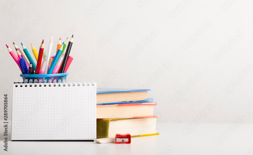 Fototapeta premium School and office supplies with books on white background