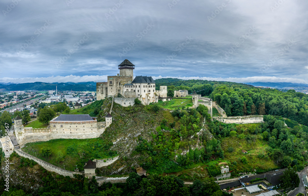 Aerial panorama view of medieval newly restored Trencin castle over the Vah river in Slovakia  with dramatic sky