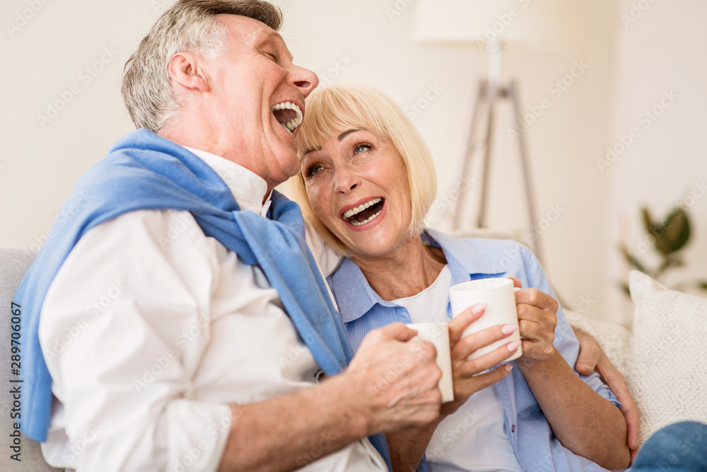 Obraz premium Happy senior couple enjoying tea and laughing