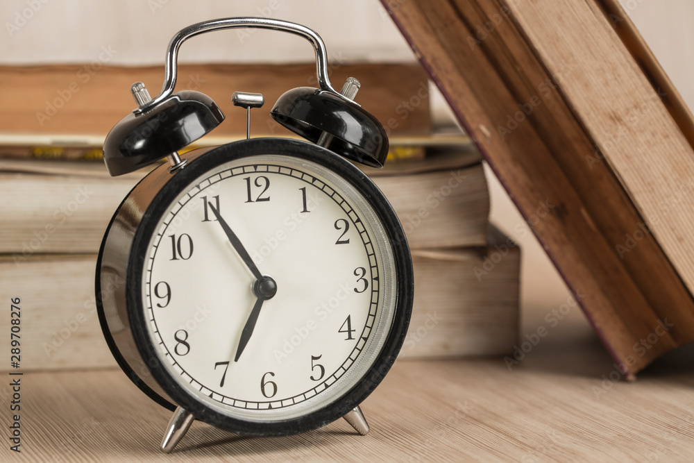 Alarm clock on reading table with color pencil background Alarm clock on reading table with color pencil background