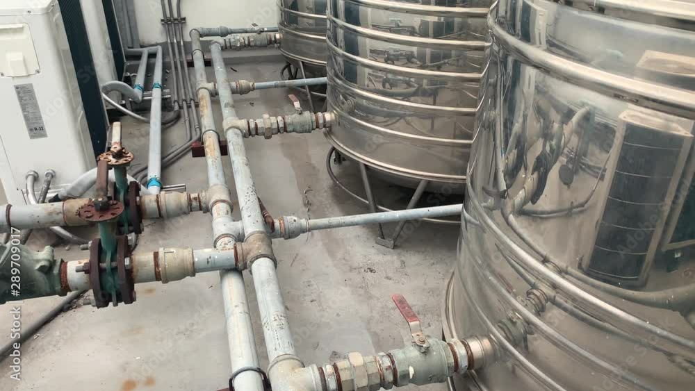 Metal tanks indoors, industry concept, deep focus tilt down medium shot Metal tanks indoors, industry concept, deep focus tilt down medium shot