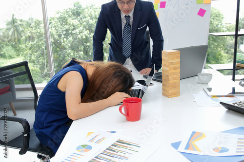 Angry boss looking afraid stressed tired employee in workplace of office.