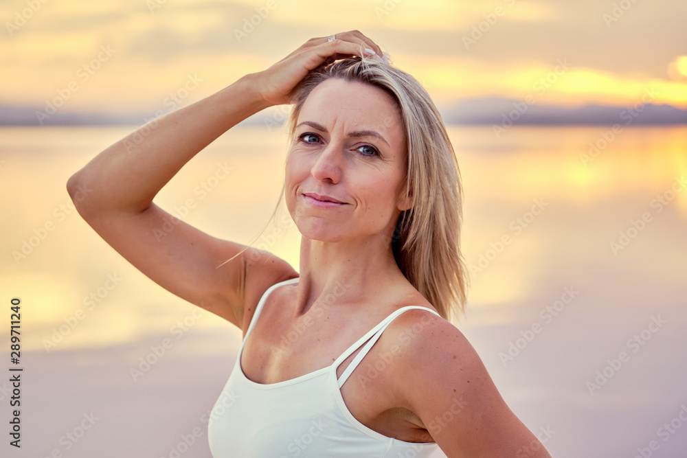 Middle-aged sportive woman posing during sunset on nature Middle-aged sportive woman posing during sunset on nature
