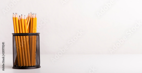 Yellow pencils in stationery glass isolated on white background