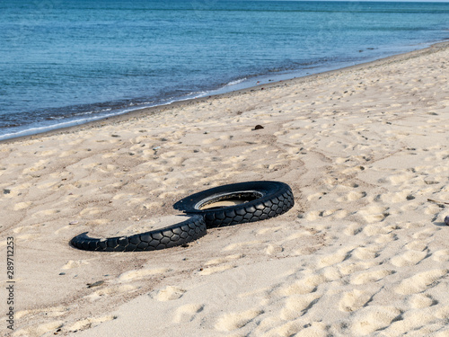 view of the sandy beach by the Baltic Sea. Seashore with old car tires and concrete, human waste, Curonian Spit, Russia