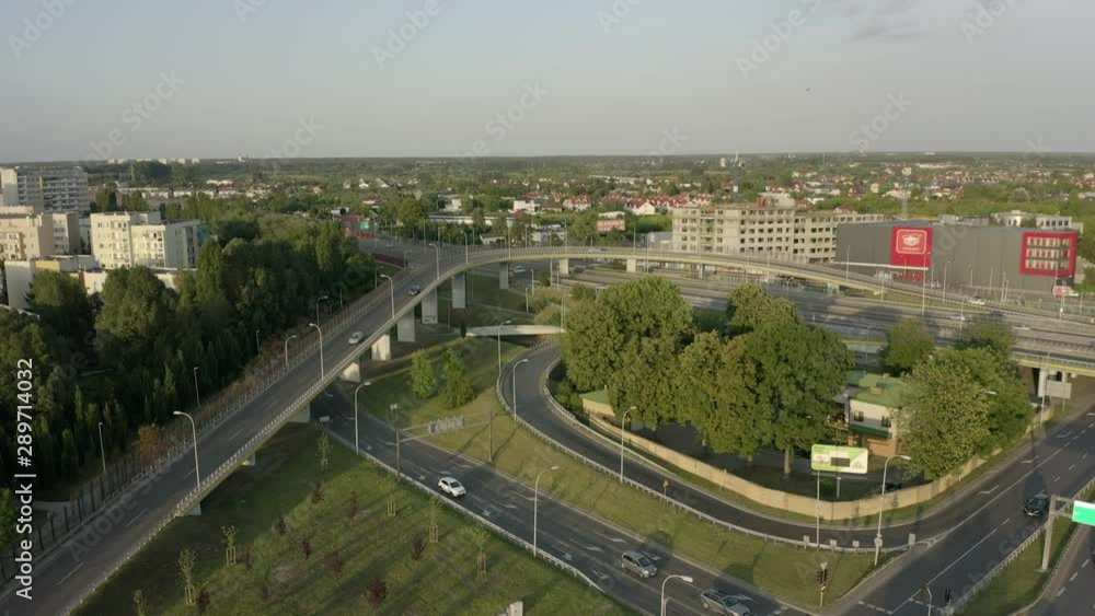 Aerial view on the movement of cars on the overpasses at the intersection with the ring road and the exit from the city. Drone Shot of city traffic in a suburb of Warsaw on a freeway at sunset. 4K Aerial view on the movement of cars on the overpasses at the intersection with the ring road and the exit from the city. Drone Shot of city traffic in a suburb of Warsaw on a freeway at sunset. 4K