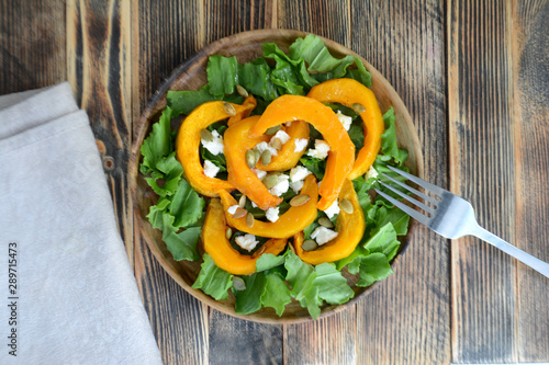 Warm autumn pumpkin salad with seeds and soft cheese Healthy food concept