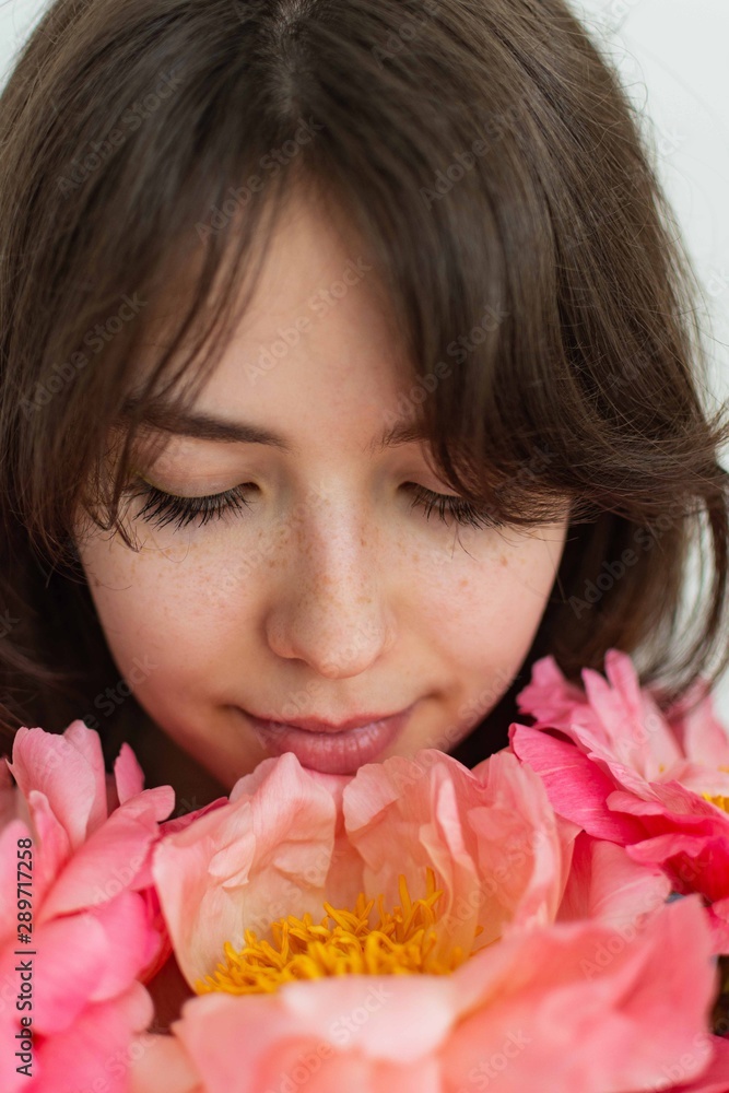 Beautiful happy girl smiling on her birthday, face of a girl close up with peonies, valentine's day Beautiful happy girl smiling on her birthday, face of a girl close up with peonies, valentine's day