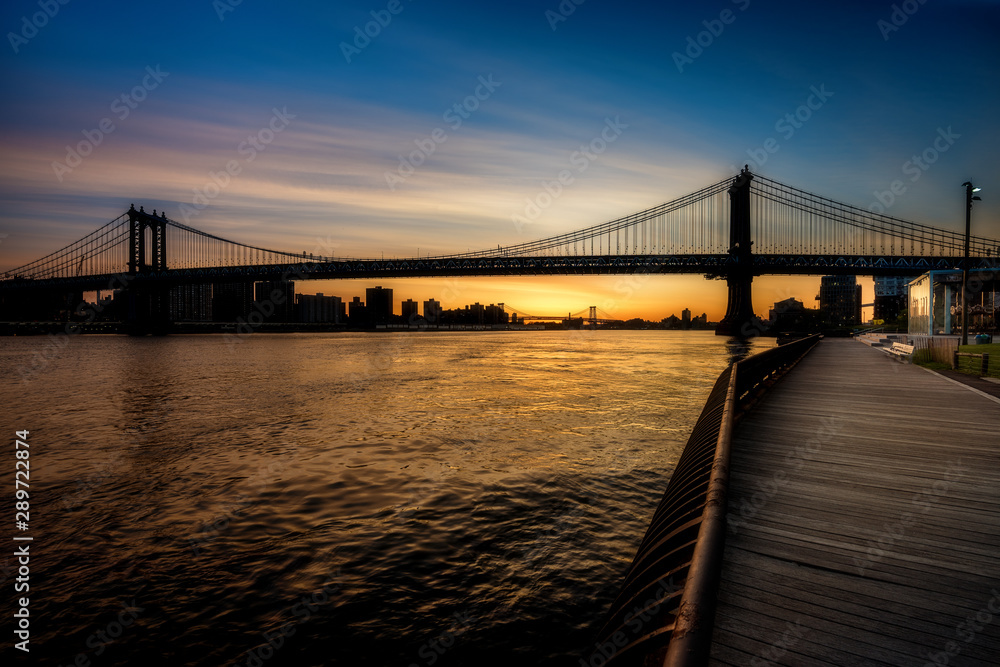 Obraz premium Boardwalk leads into the sunrise and fancy bridge New York