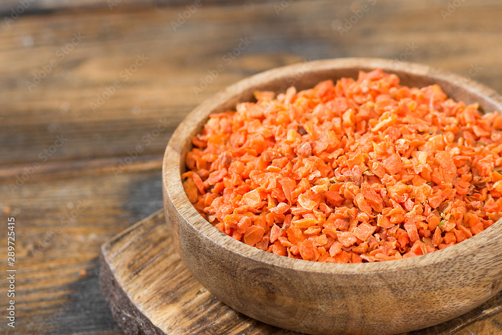 Dried carrots in a wooden bowl on a wooden table. Soup seasoning Dried carrots in a wooden bowl on a wooden table. Soup seasoning