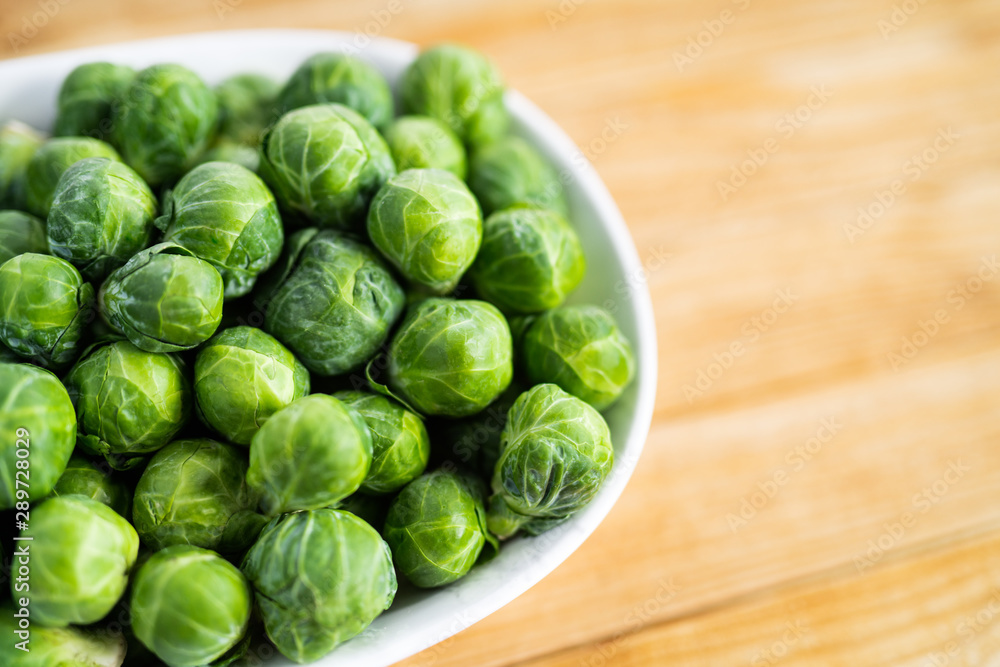 brussels sprouts in a bowl on wooden table brussels sprouts in a bowl on wooden table