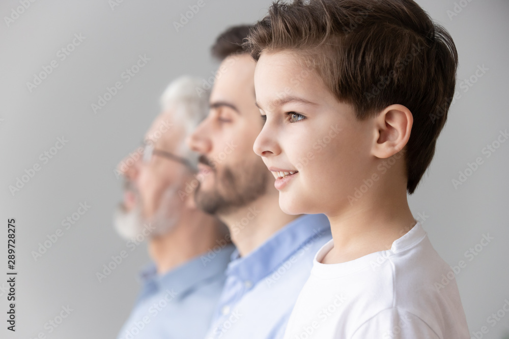 Child boy grandson stand in row with father and grandfather