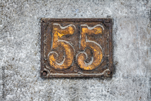Number 55  fifty five  street number sign on the wall