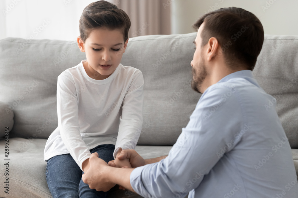 Worried single father comforting upset kid son helping with problem Worried single father comforting upset kid son helping with problem