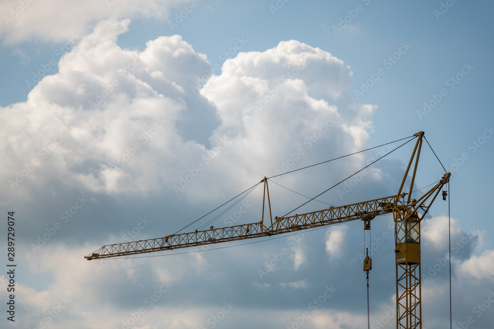 A crane for lifting heavy loads with blue sky and clouds A crane for lifting heavy loads with blue sky and clouds