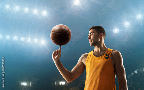 Basketball player in sports uniform turns the ball on his finger