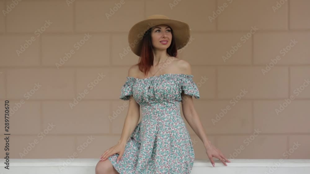 Smiles and emotions in nature. A girl in a summer dress sitting near the estate. Smiles and emotions in nature. A girl in a summer dress sitting near the estate.