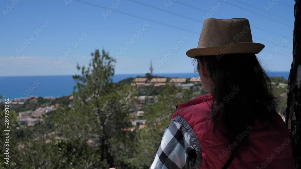 girl in the morning on top looks at the sea puts on a hat and glasses girl in the morning on top looks at the sea puts on a hat and glasses