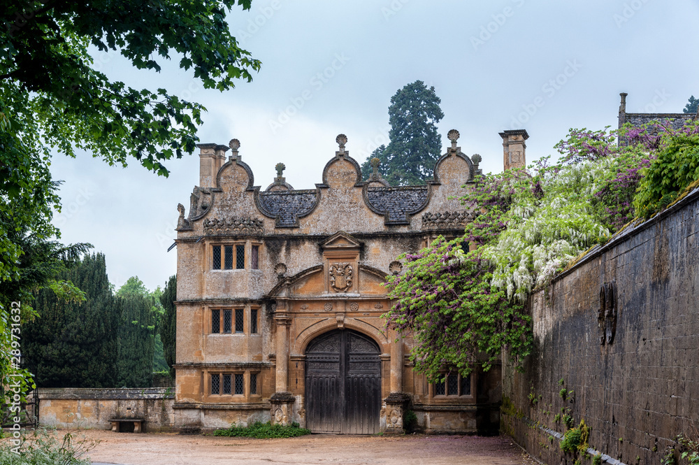 STANWAY, ENGLAND - MAY, 26 2018: Gatehouse of the Stanway Manor House built in Jacobean period in guiting yellow stone, in the Cotswold village of Stanway, Gloucestershire, Cotswolds, UK STANWAY, ENGLAND - MAY, 26 2018: Gatehouse of the Stanway Manor House built in Jacobean period in guiting yellow stone, in the Cotswold village of Stanway, Gloucestershire, Cotswolds, UK