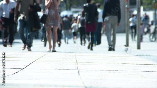 Woman with naked legs is walking on the street