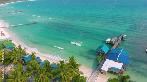 Aerial view of Sok San Beach in Koh Rong Island. Drone fly over white sand beach, turqoise water and palm trees in a tropical paradise island in Cambodia. Tropical white sand beach vacation concept photo