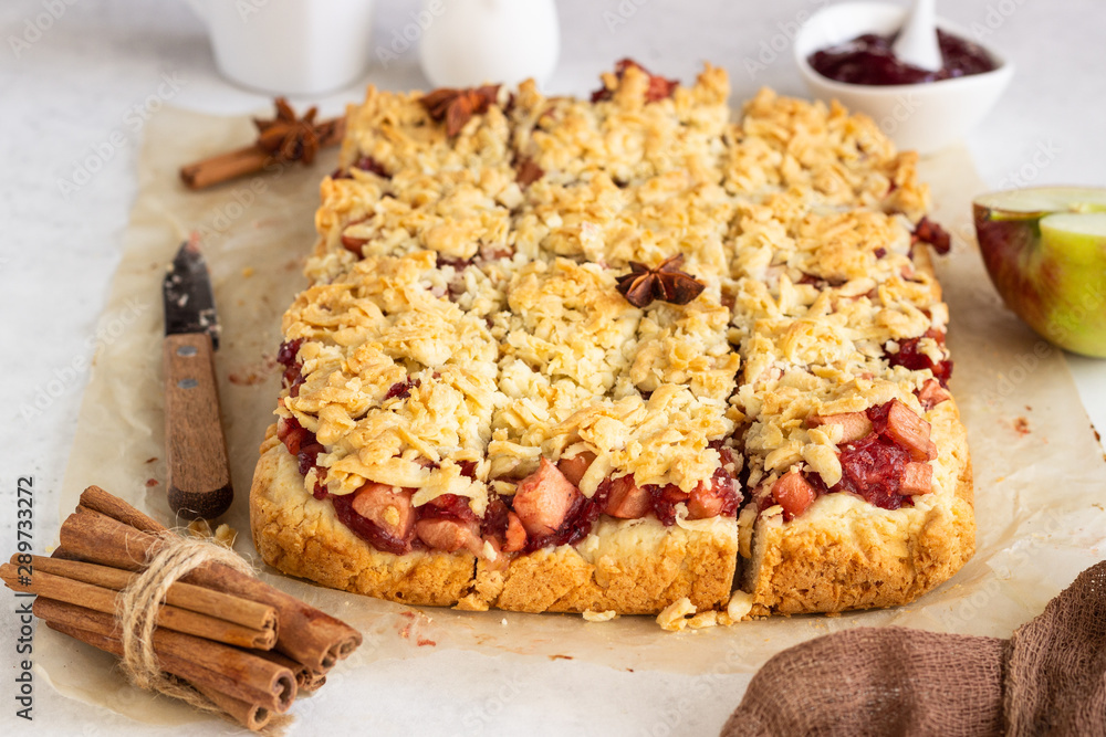 Crumble cakes with apple, red berry jam and spices filling and a cup of coffee. Autumn breakfast or dessert. Crumble cakes with apple, red berry jam and spices filling and a cup of coffee. Autumn breakfast or dessert.