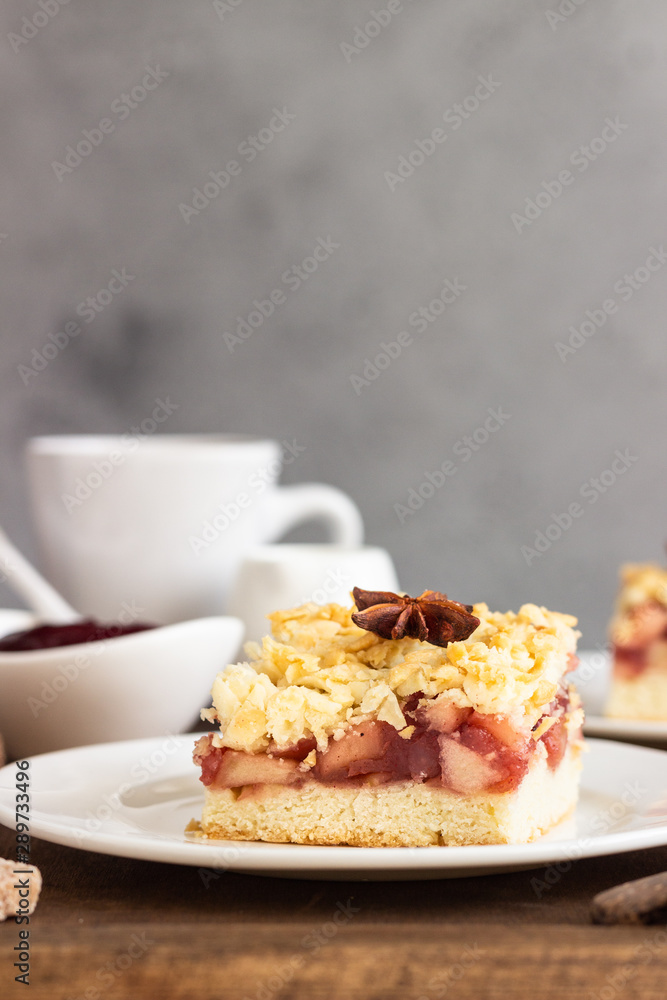 Apple, red berry jam and spices crumble topping cake and cup of coffee on wooden tray. Apple, red berry jam and spices crumble topping cake and cup of coffee on wooden tray.