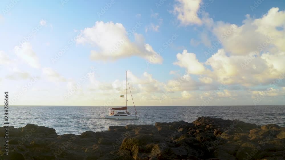 Sail Boat off the Coast of Hawaiian Ocean Coastline, Sailing on relaxed Seas During Sunset in Slow Motion Sail Boat off the Coast of Hawaiian Ocean Coastline, Sailing on relaxed Seas During Sunset in Slow Motion