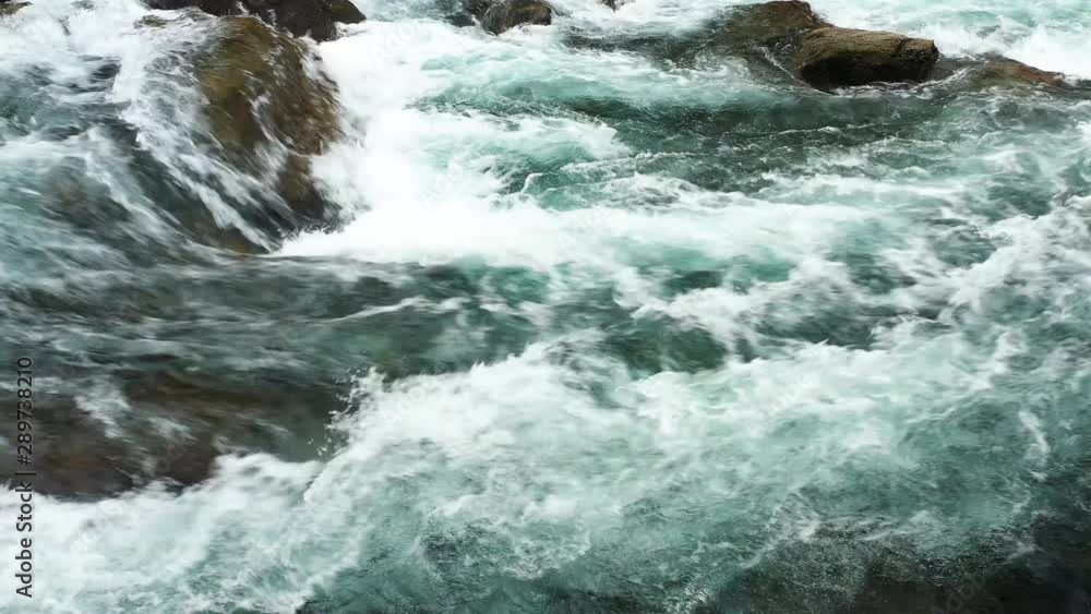 Close up shot of a cascade in fresh water, as flowing by on rocks. Small waterfall as white foam renewable energy concept to save the planet. Close up shot of a cascade in fresh water, as flowing by on rocks. Small waterfall as white foam renewable energy concept to save the planet.