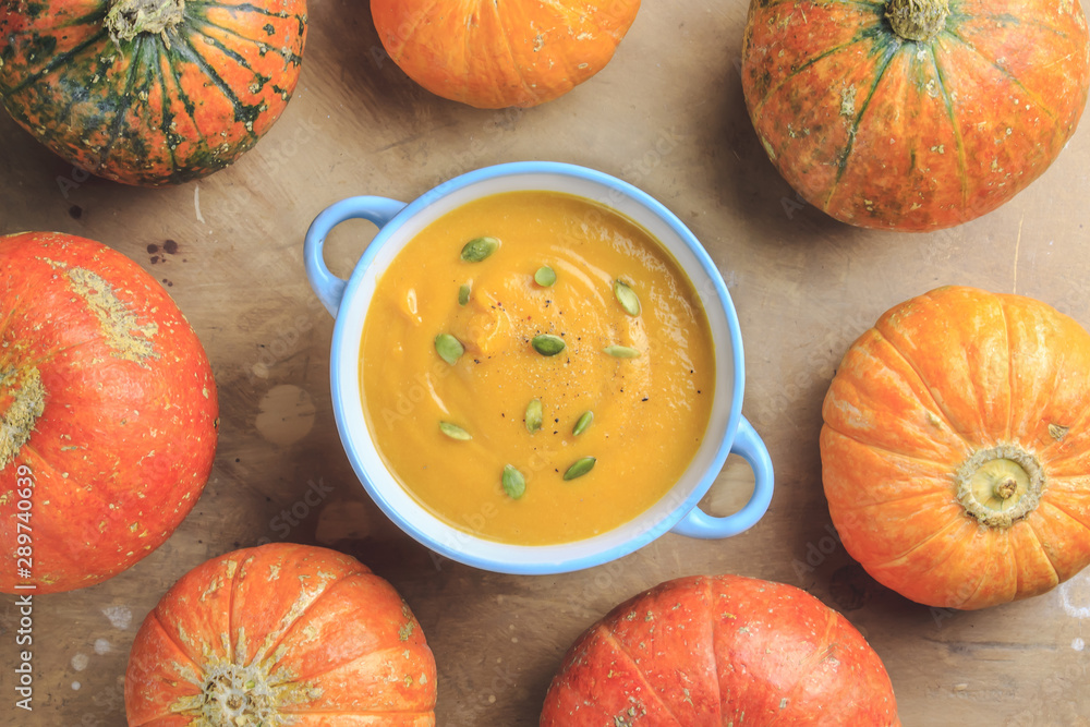 Pumpkin soup and organic pumpkins on rustic table. Pumpkin soup and organic pumpkins on rustic table.