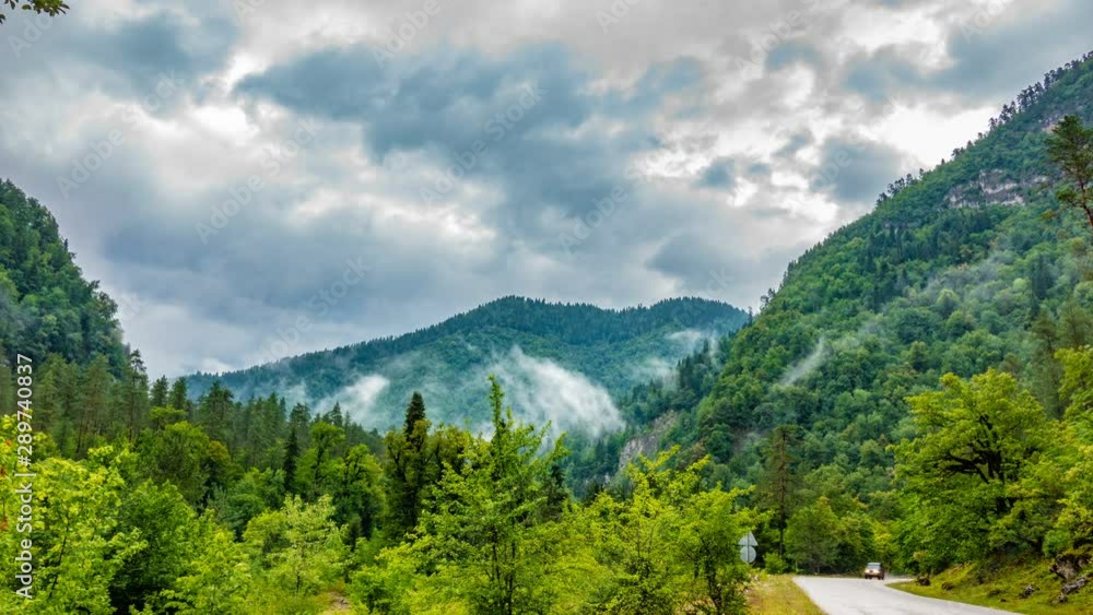 The onset of twilight in the mountains and the appearance of fog on a mountain serpentine, Evening mountain time lapse with the lights of a fast passing vehicle in the fog. The onset of twilight in the mountains and the appearance of fog on a mountain serpentine, Evening mountain time lapse with the lights of a fast passing vehicle in the fog.