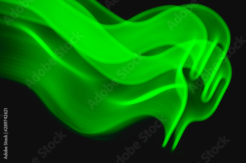 Neon green cactus LED lamp in motion as blurred abstract background on black.