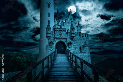 Scary Gothic castle on Halloween, old spooky house at night with moon. Fantasy view of Lichtenstein castle, Germany. 
