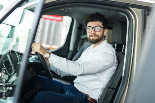 Handsome bearded man is sitting in a new car in car dealership © F8  \ Suport Ukraine