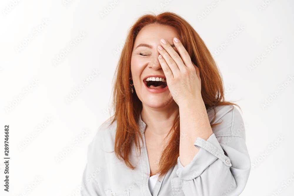Happiness, aging, beauty concept. Carefree good-looking redhead middle-aged woman laughing cheerful touch face close eyes giggle emotive have fun family circle enjoy retirement, white background Happiness, aging, beauty concept. Carefree good-looking redhead middle-aged woman laughing cheerful touch face close eyes giggle emotive have fun family circle enjoy retirement, white background