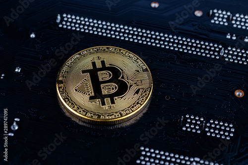 bitcoin physical shiner on black electronic board with selective focus and blur photo