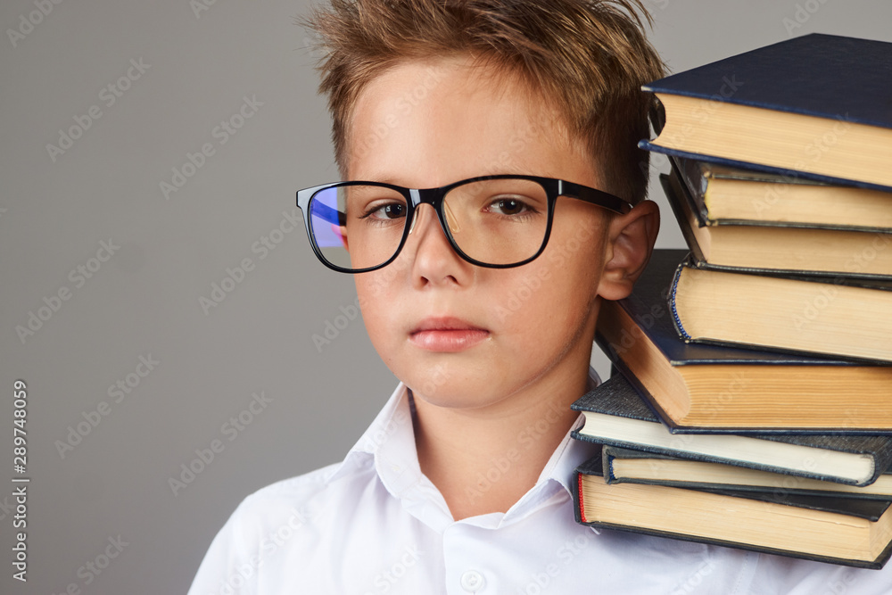 School boy holds book over white background with copy space, close-up School boy holds book over white background with copy space, close-up