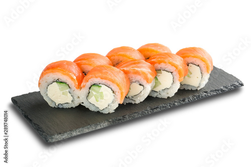 Sushi Rolls with salmon, cucumber, nori leaf and Cream Cheese inside on black slate or stone shale surface isolated