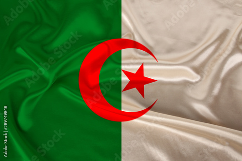 photo of the national flag of algeria on a luxurious texture of satin, silk with waves, folds and highlights, closeup, copy space, travel concept, economy and state policy, illustration