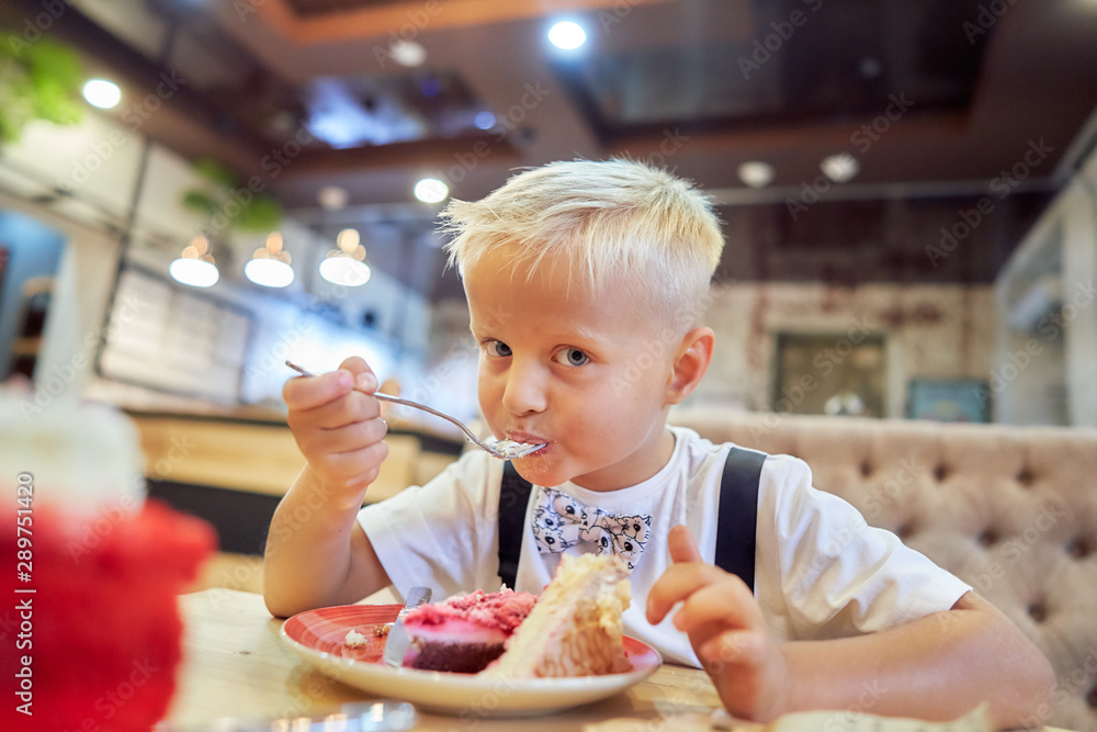 little boy in a cafe eating a cake little boy in a cafe eating a cake