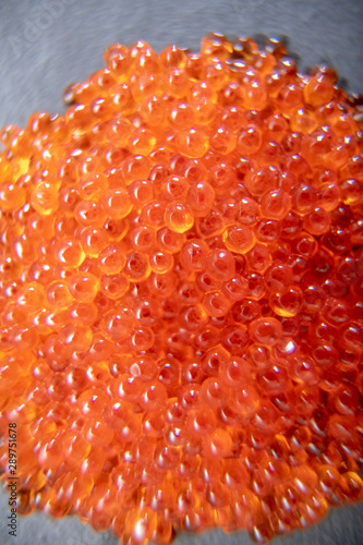 Red caviar close up on the grey stone background
