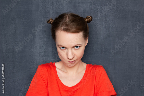 Portrait of funny obstinate girl looking with displeasure at camera © Andrei Korzhyts